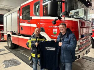 Preventos Inhaber übergibt Feuerwehrmann ein T-Shirt