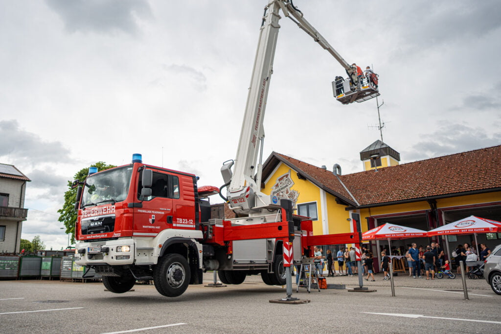 Menschen beim Feuerwehrauto